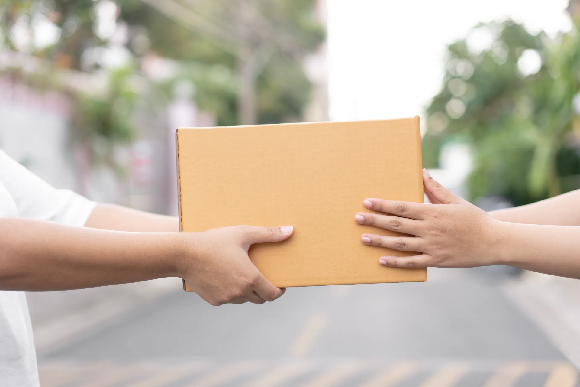 A box being handed over during the day in an urban setting