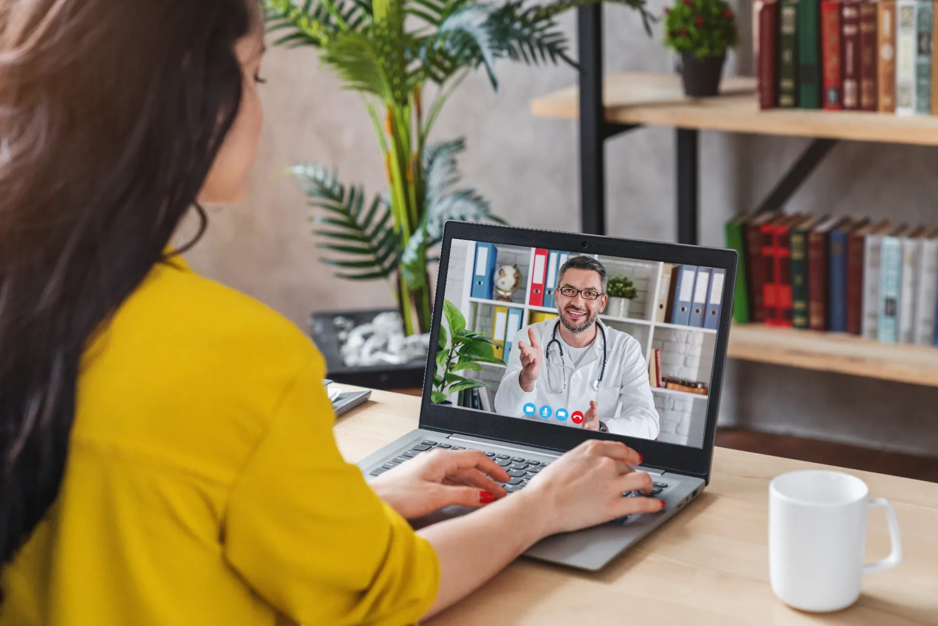 Back view of a woman on a video call with her doctor